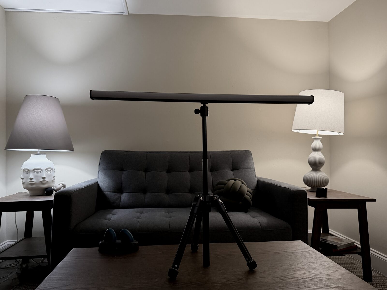 The Room with the EMDR light bar on a tripod between two warm lamps over a low couch, a Brainspotting double-pointer visible on the side table at left